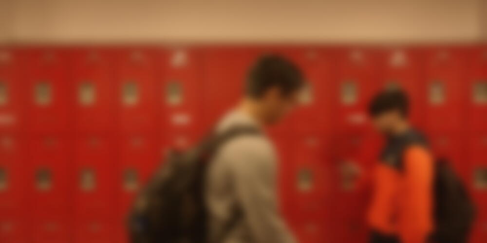 teens walking in front of school lockers