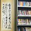 AEMS Library with bookshelves and a hanging scroll